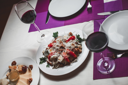 glasses with red wine on the table in the restaurantの写真素材