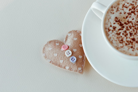 Beautiful coffee Cup with heart on a white wooden backgroundの写真素材