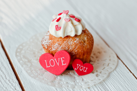 Beautiful cakes cupcakes on a white wooden table from the heartの写真素材