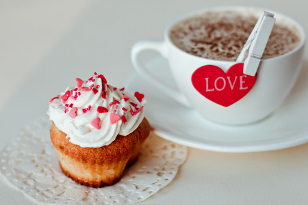 Beautiful coffee Cup with heart cupcake on white wooden backgroundの写真素材