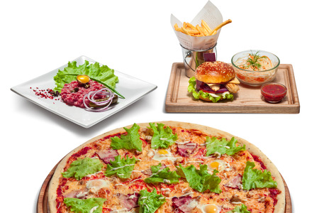 fast food and unhealthy eating concept - close up of hamburger or cheeseburger, deep-fried french fries, pizza and ketchup on wooden table top viewの写真素材