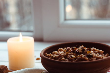 Christmas porridge with candles on white wooden backgroundの写真素材