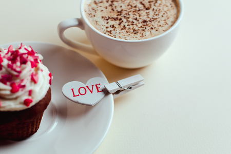 Beautiful coffee Cup with heart cupcake on white wooden backgroundの写真素材
