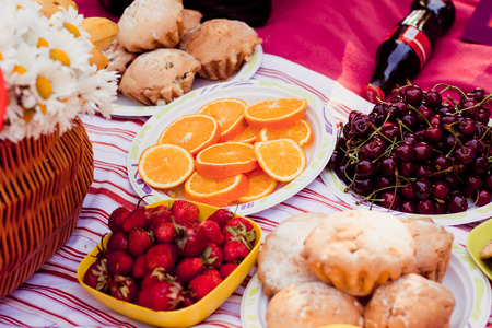 oranges petioles and strawberries laid out on plates on the tableの写真素材