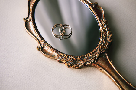 Beautiful wedding rings on a vintage mirrorの写真素材