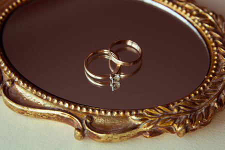 Beautiful wedding rings on a vintage mirrorの写真素材