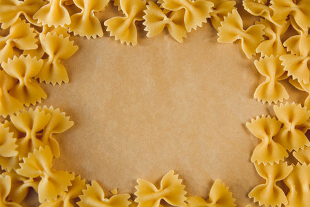 Beautiful frame made of pasta on parchment paper with space for textの写真素材