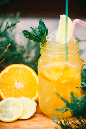 Lemonade in the jug with lemons with mint on the tableの写真素材