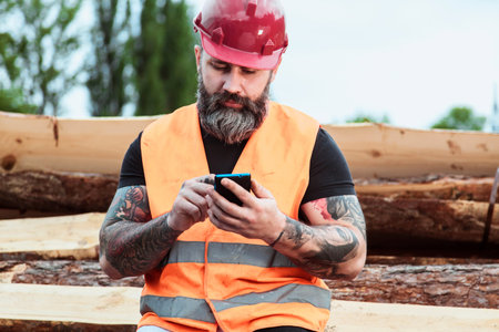 Worker in overalls and with a tattoo are checking the quality of materials and other inspections,...