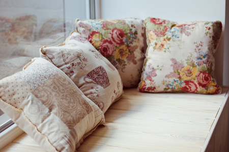 Beautiful pillows on the wide windowsill in the afternoonの写真素材