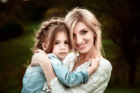 A mother and child in nature. The little girl clung to the mother.の写真素材