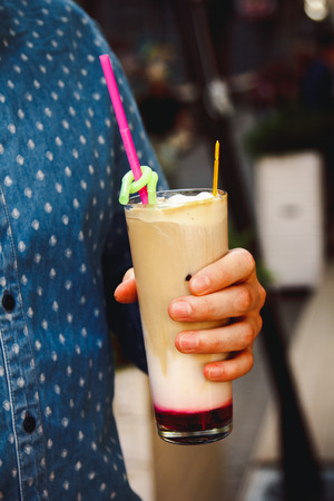 Beautiful cocktails with fruits and berries in the hands of menの写真素材