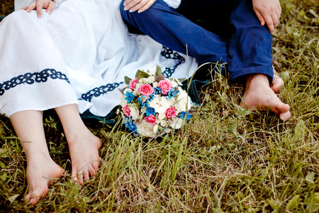 bridal bouquet of white roses on a green meadow and newlywedsの写真素材