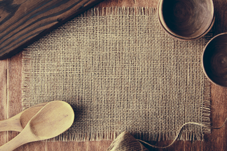 Wooden spoons and bowls on the background of burlap on the tableの写真素材