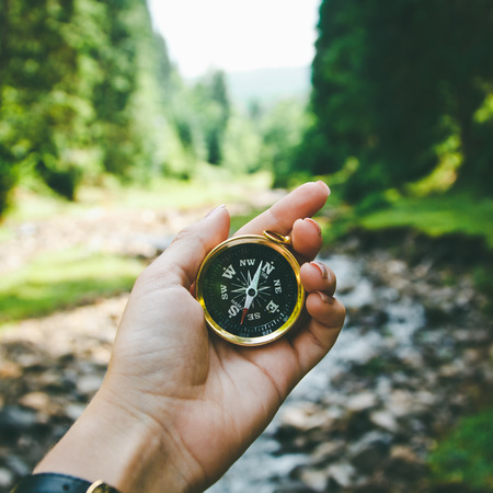 Compass in the hand on the nature background.の写真素材