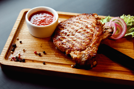Beautiful juicy pork steak cooked on the grill with caramelized onionsの写真素材