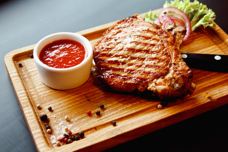 Beautiful juicy pork steak cooked on the grill with caramelized onionsの写真素材