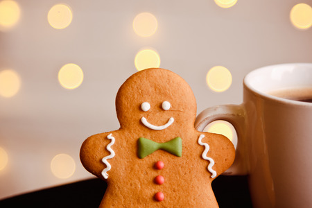 Gingerbread man standing at cup of coffee on a blurred background. Christmas cardの写真素材