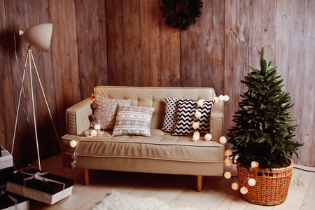 Decorated Christmas tree with beautiful sofa and garlandの写真素材