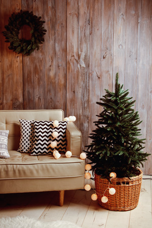 Decorated Christmas tree with beautiful sofa and garlandの写真素材