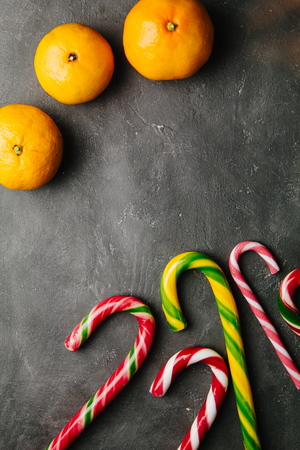 Beautiful Colorful Christmas candy and tangerines on dark backgroundの写真素材