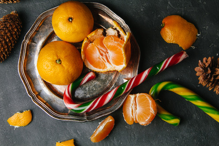 Beautiful Colorful Christmas candy and tangerines on dark backgroundの写真素材