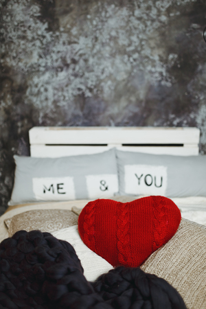 Romantic interior loft-style for Valentine's day with bed, pillows and heartの写真素材