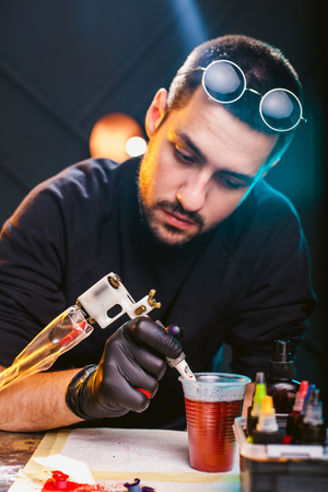 master tattoo artist prepares tools for tattooingの写真素材