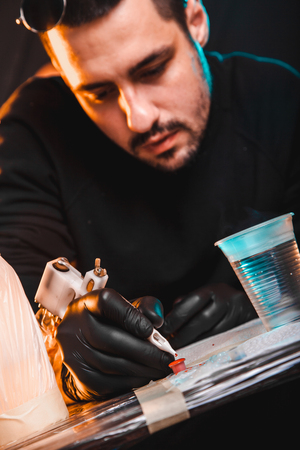 master tattoo artist prepares tools for tattooingの写真素材