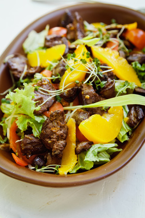 Beautiful fresh warm Chinese salad with chicken heartsの写真素材
