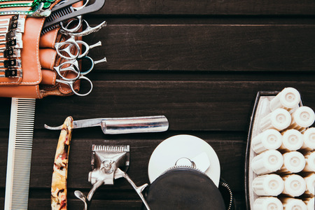 Beautiful professional tools professional Barber kits, scissors, a sharp razor, mechanical and electronic hair clippers, hair curlers, clips. Vintage stylish background for beauty salon with free spaceの写真素材