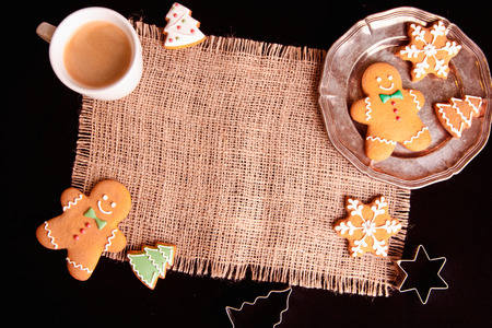 Beautiful Christmas background cookies and cap of coffee on dark backgroundの写真素材