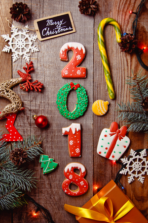 Beautiful Christmas background with gingerbreads, sweets and gift on wooden background. Merry Christmas postcard 2018の写真素材
