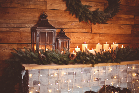 Burning candles in the New Year's interior with a Christmas fireplaceの写真素材