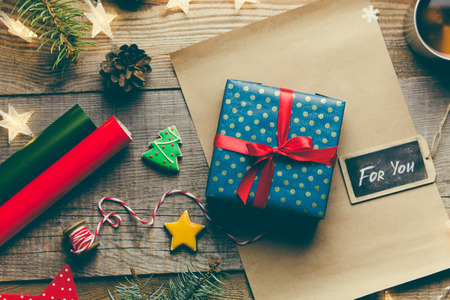 Beautiful Christmas background with a New Year dÃ©cor, a sheet of old paper, garland and gifts on a wooden background. Merry Christmas postcard.の写真素材