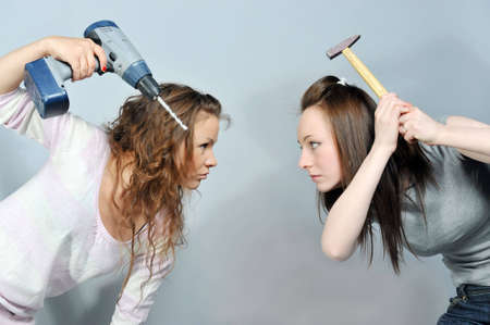 two girls in opposition with drill and hummerの写真素材