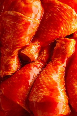 Raw marinated chicken legs in spicy tomato sauce, top view.の写真素材