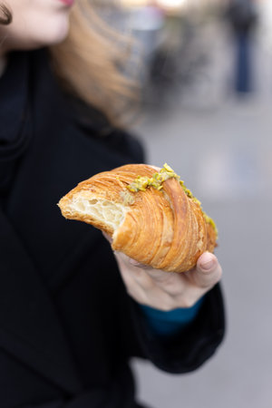 Hand Holding Fresh Pistachio Croissant Outdoorsの写真素材