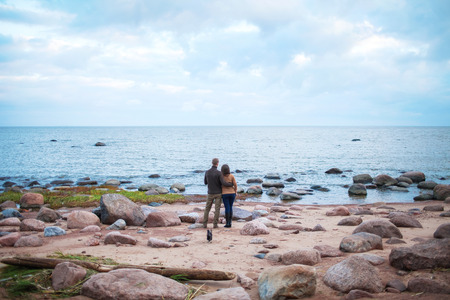 Young couple hugging on a rocky seashoreの写真素材