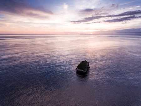 Sunset aerial view Bali ocean. Red sky and amazing cliff. View by drone.
