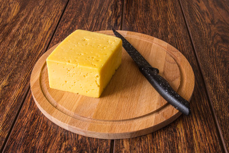 Cheese on a wooden Board and a knife