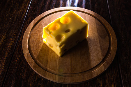 Cheese on a wooden Board in a contoured light