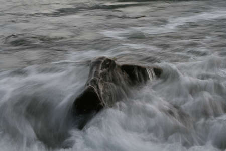 A wave breaking on a rockの写真素材