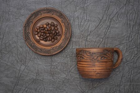 Homemade cup and saucer made of glazed clay.の写真素材