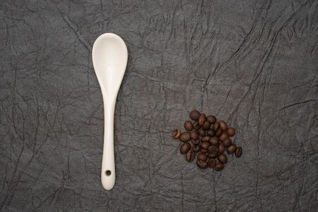 White glazed porcelain coffee spoon on artificial leather background.の写真素材