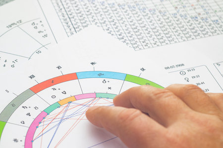 The magic of the workplace of a modern astrologer. Astrological charts scattered across the table,...
