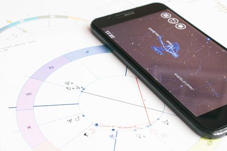 The desktop of an astrologer. Gadgets help the modern Oracle to make calculations. The magical mysterious atmosphere of the working environment of the predictor of the future.の写真素材