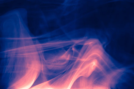 Clouds of colored flowing smoke on a dark background. Smoky extravaganza. Flying smoky vague fantasies.の写真素材
