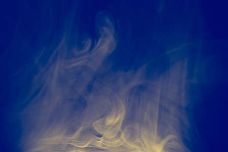 Clouds of colored flowing smoke on a dark background. Smoky extravaganza. Flying smoky vague fantasies.の写真素材