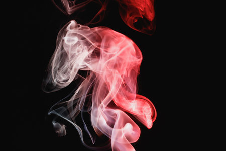 Red smoke on a black background. Colored smoke. Incense stick smoke, illuminated by red light.
